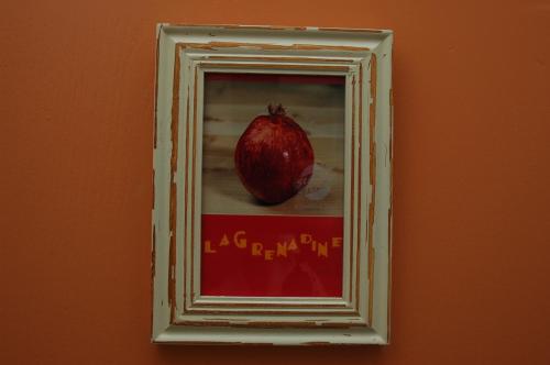 a picture of a pomegranate in a frame on a wall at La Palombiere in Lucmau