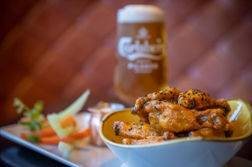 a bowl of food with a bottle of beer at Court Yard Hotel in Leixlip