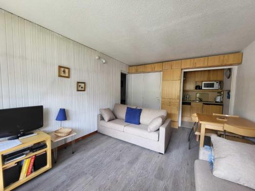 un salon avec un canapé et une télévision dans l'établissement Tignes : 2 pièces, 4 pers, proche des pistes, balcon sud-ouest, wifi, animaux ok - FR-1-449-119, à Tignes
