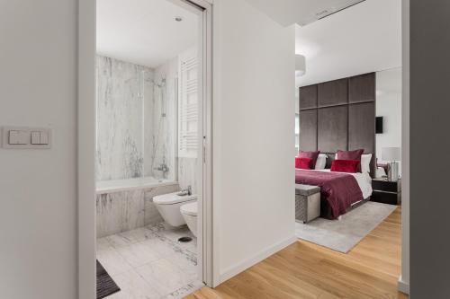 een slaapkamer met een bed, een toilet en een bad bij Modern 3BR with Terrace in Benfica in Lissabon