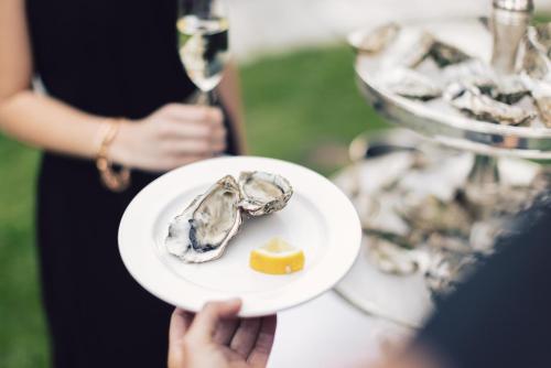 a person holding a plate of oysters and cheese at Alpenpalace Luxury Hideaway & Spa Retreat in Lutago