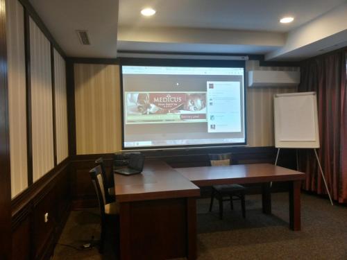 a meeting room with a large projection screen in a building at SPA Hotel Medicus in Varshets