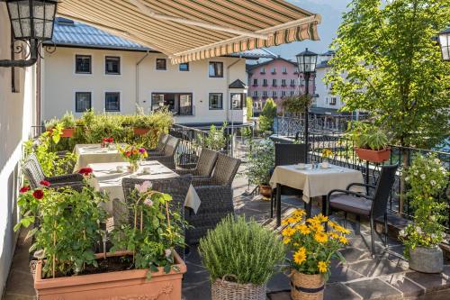 an outdoor patio with tables and chairs and flowers at Hotel Resch in Kitzbühel