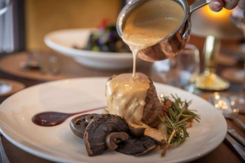 a plate of food with sauce being poured onto it at Court Yard Hotel in Leixlip