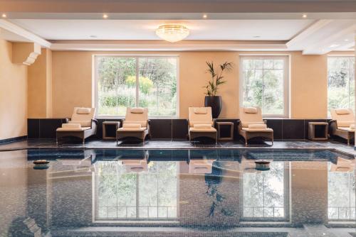 a waiting room with chairs and a pool at Alpenpalace Luxury Hideaway & Spa Retreat in Lutago