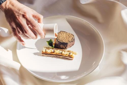 a person holding a plate with a piece of food at Alpenpalace Luxury Hideaway & Spa Retreat in Lutago