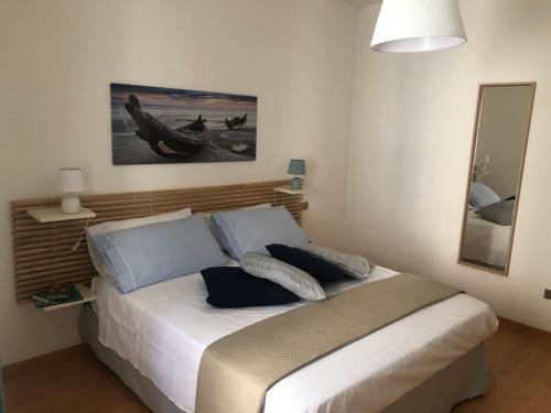 ein Schlafzimmer mit einem Bett in einem Zimmer mit einem Spiegel in der Unterkunft Ankon Apartment Palazzo Mazzini in Ancona