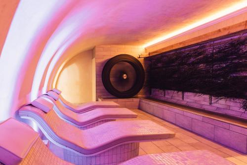 a purple room with a bench and a painting on the wall at Alpenpalace Luxury Hideaway & Spa Retreat in Lutago