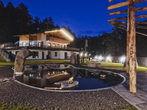 a house with a pond in front of it at night at Sinnes Waldrast in Tarrenz