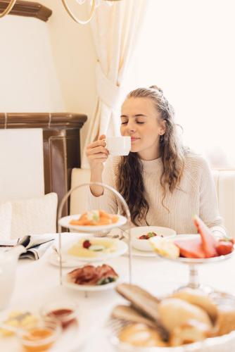 a woman sitting at a table eating food at Alpenpalace Luxury Hideaway & Spa Retreat in Lutago
