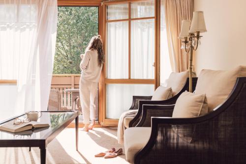a woman standing in a room looking out the window at Alpenpalace Luxury Hideaway & Spa Retreat in Lutago