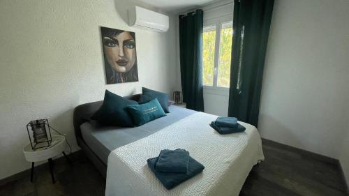 a bedroom with a bed with blue pillows on it at Jolie villa à UZES, climatisée avec piscine in Uzès