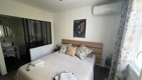 une petite chambre avec un lit et une fenêtre dans l'établissement Jolie villa à UZES, climatisée avec piscine, à Uzès