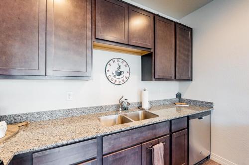 a kitchen with a sink and a clock on the wall at Hideaway in the Sun in Flagstaff