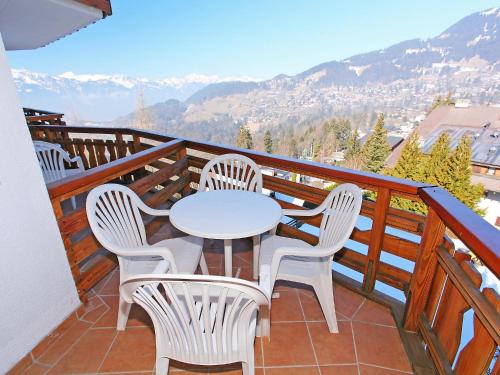 a white table and chairs on a balcony with mountains at Apartment Le Bristol A46 by Interhome in Villars-sur-Ollon