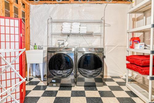 zwei Waschmaschinen in einer Waschküche mit kariertem Boden in der Unterkunft Freedom Cove in Bumpass