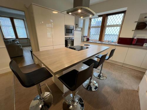 a kitchen with a large wooden table and chairs at Ashley House Contemporary 4 Bedroom Stay for 13 in Inverness