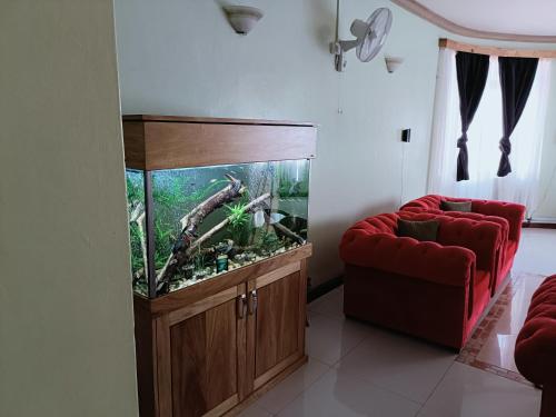 a living room with a fish tank and a red couch at Azuri residence homestay in Mombasa