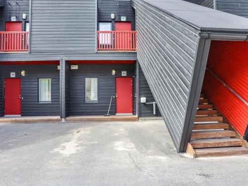 un edificio con 2 puertas rojas y una escalera en Holiday Home Skivillas 47 ukkohalla - a7 by Interhome, en Hyrynsalmi