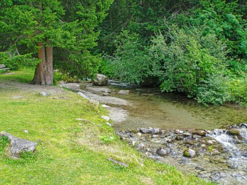 a stream of water with a tree and a bench at Apartment Elisabeth by Interhome in Ochsengarten