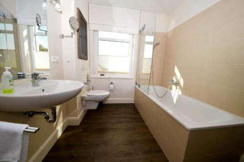 a bathroom with a sink and a tub and a toilet at Fehmarn-Ostseeferien"Strandleev3" 1423 App 3 in Fehmarnsund