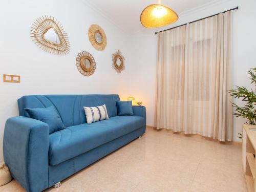 un sofá azul en una sala de estar con espejos en Apartment Portbou by Interhome, en Portbou