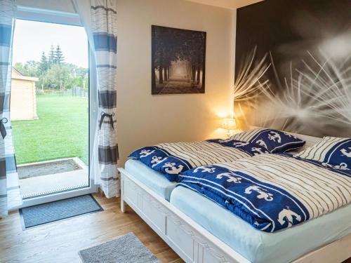 a bedroom with a bed with blue pillows and a window at Holiday Home Pusteblume by Interhome in Hessenburg