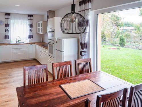a kitchen with a table and chairs and a large window at Holiday Home Pusteblume by Interhome in Hessenburg