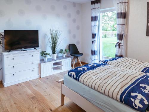 a bedroom with a bed and a tv and a window at Holiday Home Pusteblume by Interhome in Hessenburg