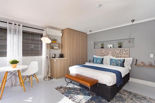 a bedroom with a large bed and a table at Blouberg Studio Apartment in Bloubergstrand