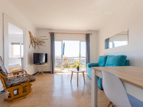 een woonkamer met een blauwe bank en een televisie bij Apartment Tabor-2 by Interhome in Torredembarra