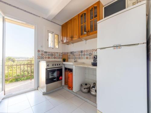 een keuken met een koelkast en een groot raam bij Apartment Tabor-2 by Interhome in Torredembarra