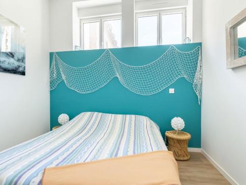 une chambre avec un lit avec une tête de lit bleue dans l'établissement Apartment Vue Solidor-1 by Interhome, à Saint-Malo