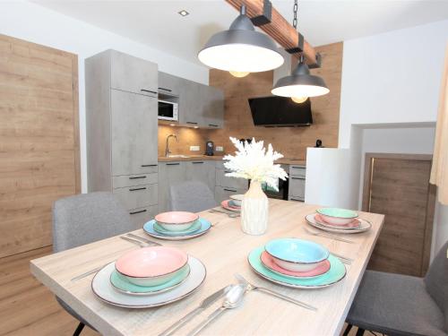 a wooden table with plates and utensils in a kitchen at Apartment Bernadette by Interhome in Aschau