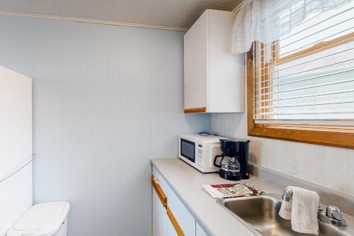 a small kitchen with a sink and a microwave at Coastal Calm A in Wells