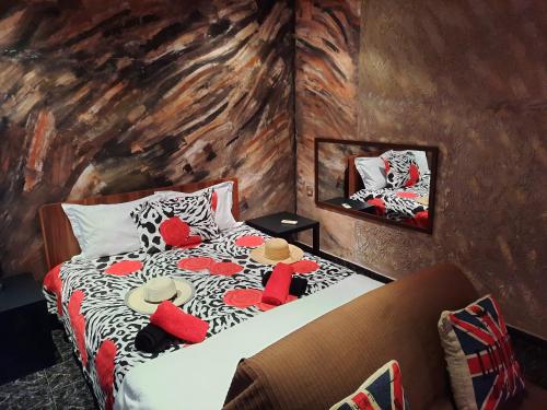 a bedroom with a bed with red and white pillows at Algreco Naturists & Swinging in Asgourou