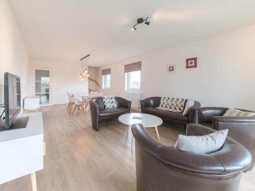 a living room with leather furniture and a table at Apartment Rozenhof with parking by Interhome in Bredene