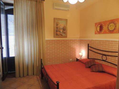 a bedroom with a red bed in a room at B&B I Mastrazzi Riposto Giarre in Riposto