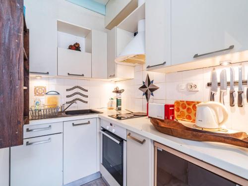 une cuisine avec des placards blancs et un comptoir dans l'établissement Apartment Parc d'hiver by Interhome, à Mimizan