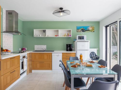 une cuisine avec des murs verts et une table et des chaises dans l'établissement Holiday Home Palet Breton by Interhome, à Locquirec
