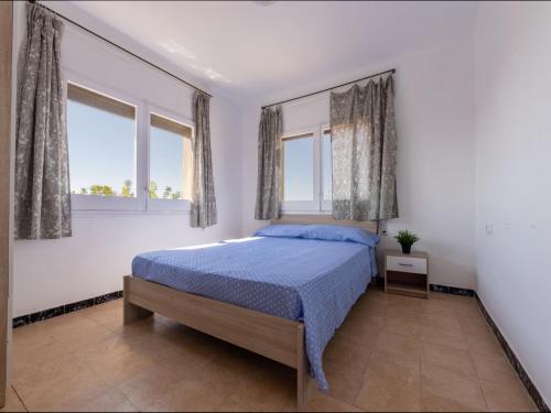 a bedroom with a bed and two windows at Apartment Tabor-1 by Interhome in Torredembarra