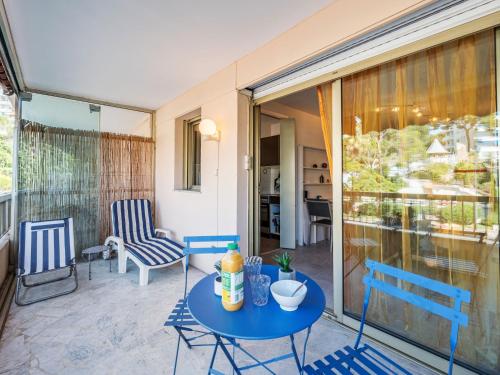 d'une terrasse avec une table et des chaises bleues. dans l'établissement Studio Le Mercure by Interhome, à Cannes