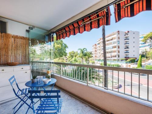 un balcon avec une table et des chaises et une grande fenêtre dans l'établissement Studio Le Mercure by Interhome, à Cannes