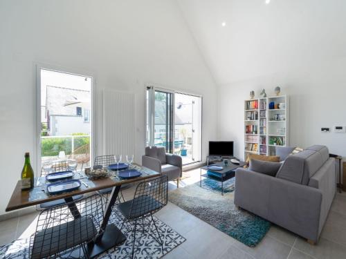 Apartment Le Clos Moguer-1 by Interhome في كويبيرون: غرفة معيشة مع طاولة وكراسي