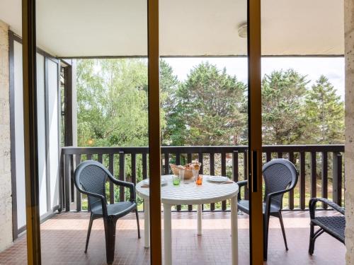 un patio avec une table et des chaises sur un balcon dans l'établissement Apartment Les Princes-2 by Interhome, à Deauville