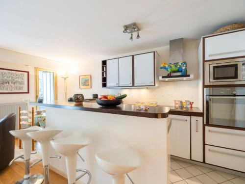 une cuisine avec des placards et des tabourets blancs dans l'établissement Apartment Les Princes-2 by Interhome, à Deauville
