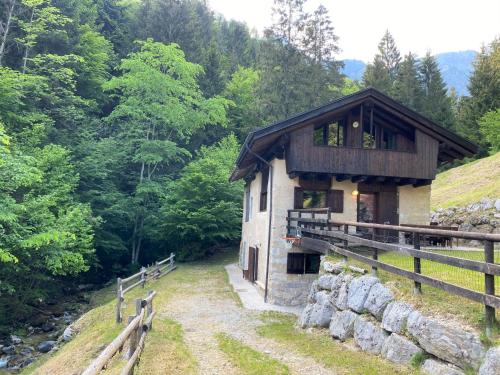 een gebouw op een heuvel naast een bos bij Chalet Sally by Interhome in Ledro