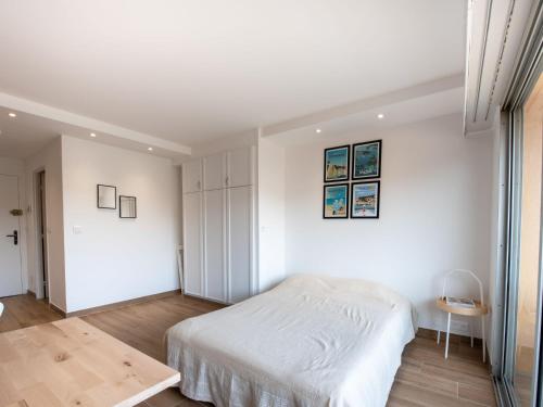 une chambre blanche avec un lit et une table dans l'établissement Studio Les Pradels by Interhome, à Cavalaire-sur-Mer