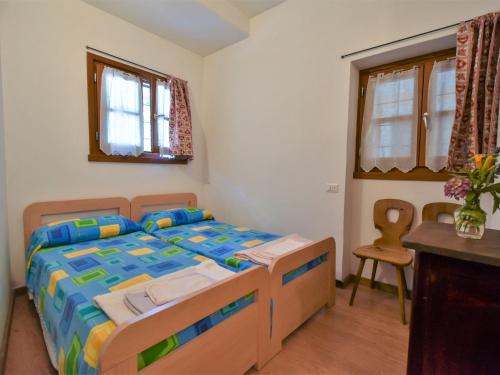 ein Schlafzimmer mit einem Bett, einem Tisch und einem Stuhl in der Unterkunft Apartment La Cá Vegia-1 by Interhome in San Cassiano