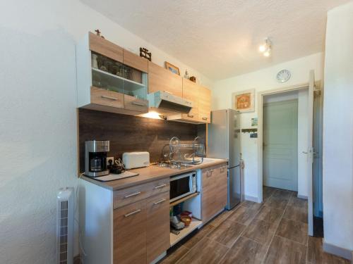 une cuisine avec des armoires en bois et un réfrigérateur dans l'établissement Apartment L'Eau Blanche by Interhome, à Cavalaire-sur-Mer